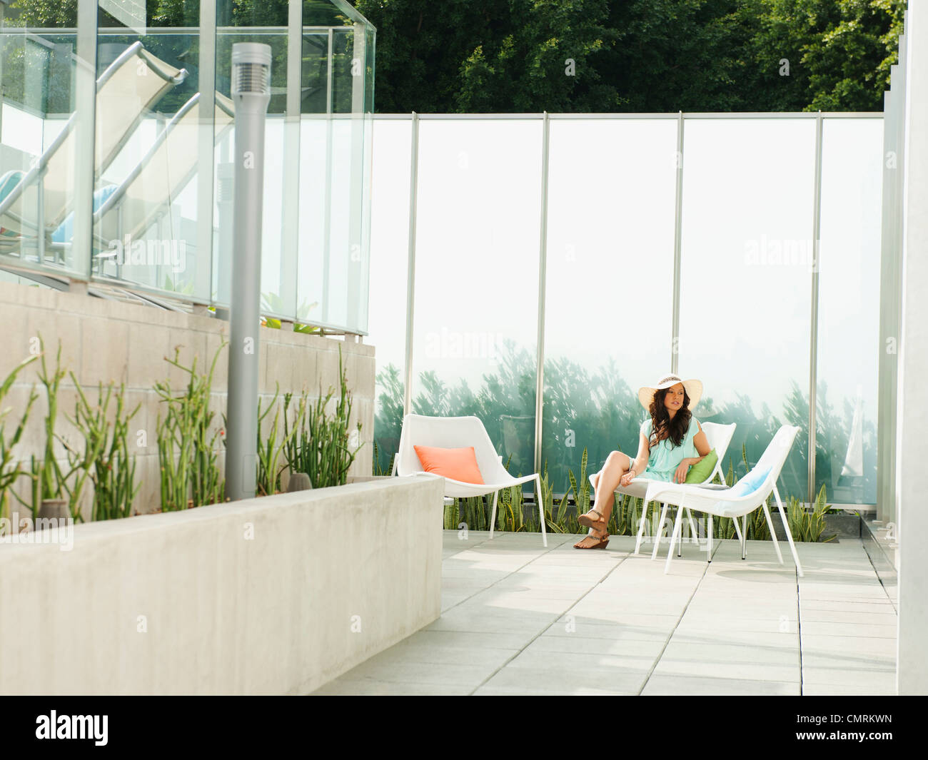 Mixed race woman relaxing on patio Stock Photo