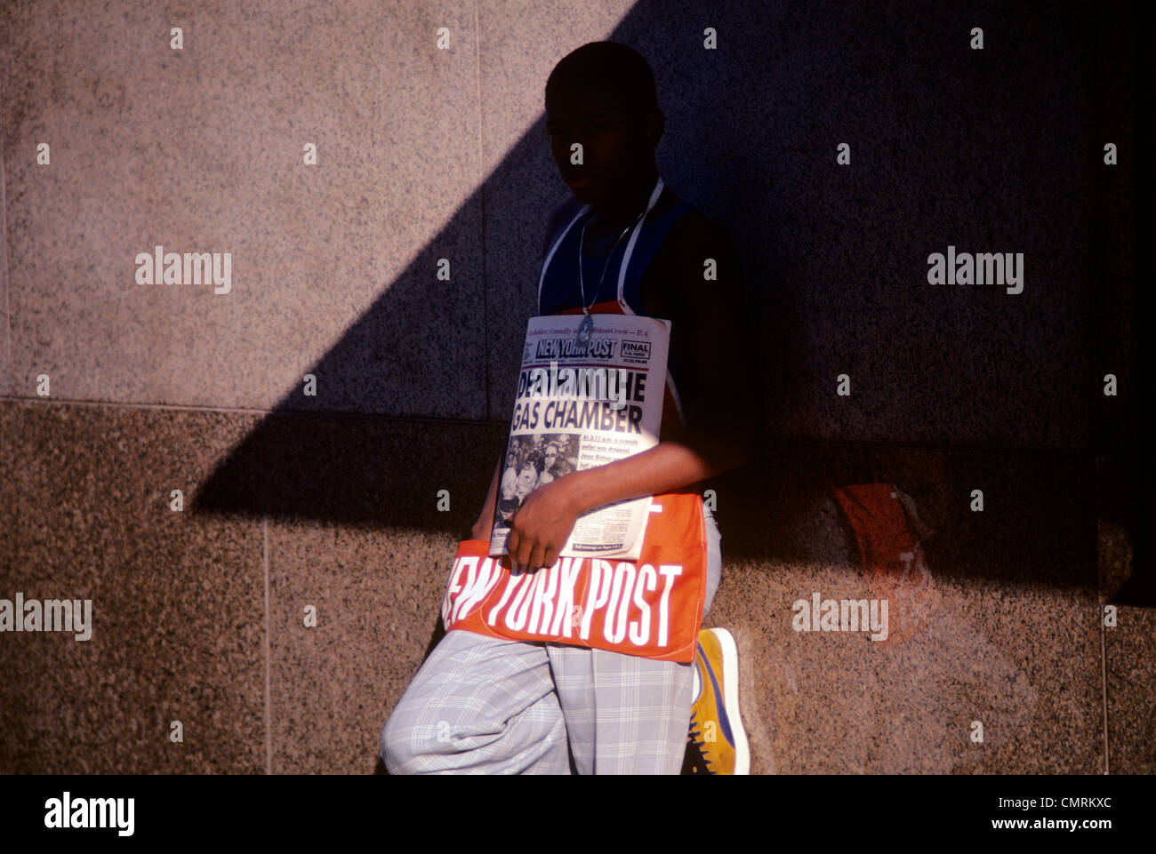1980 1980s RETRO AFRICAN AMERICAN BOY TEEN SELLING NEW YORK POST NEWSPAPERS Stock Photo