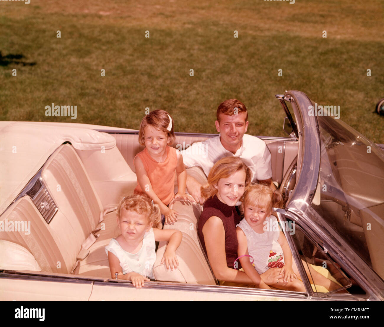 1960 1960s 1970 1970s FAMILY 5 SMILING IN OPEN CONVERTIBLE WHITE CAR RETRO RRR PORTRAIT MAN WOMAN MOTHER FATHER 3 GIRLS Stock Photo