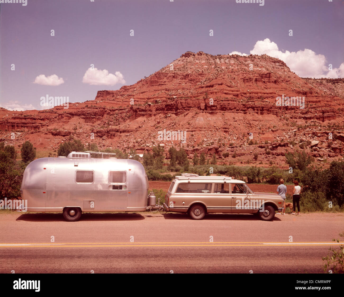 1970 1970s STATION WAGON CAR TRAILER RV NEW MEXICO HIGHWAY TOURIST MAN WOMAN LOOKING MESA FORMATION AIRSTREAM RETRO Stock Photo