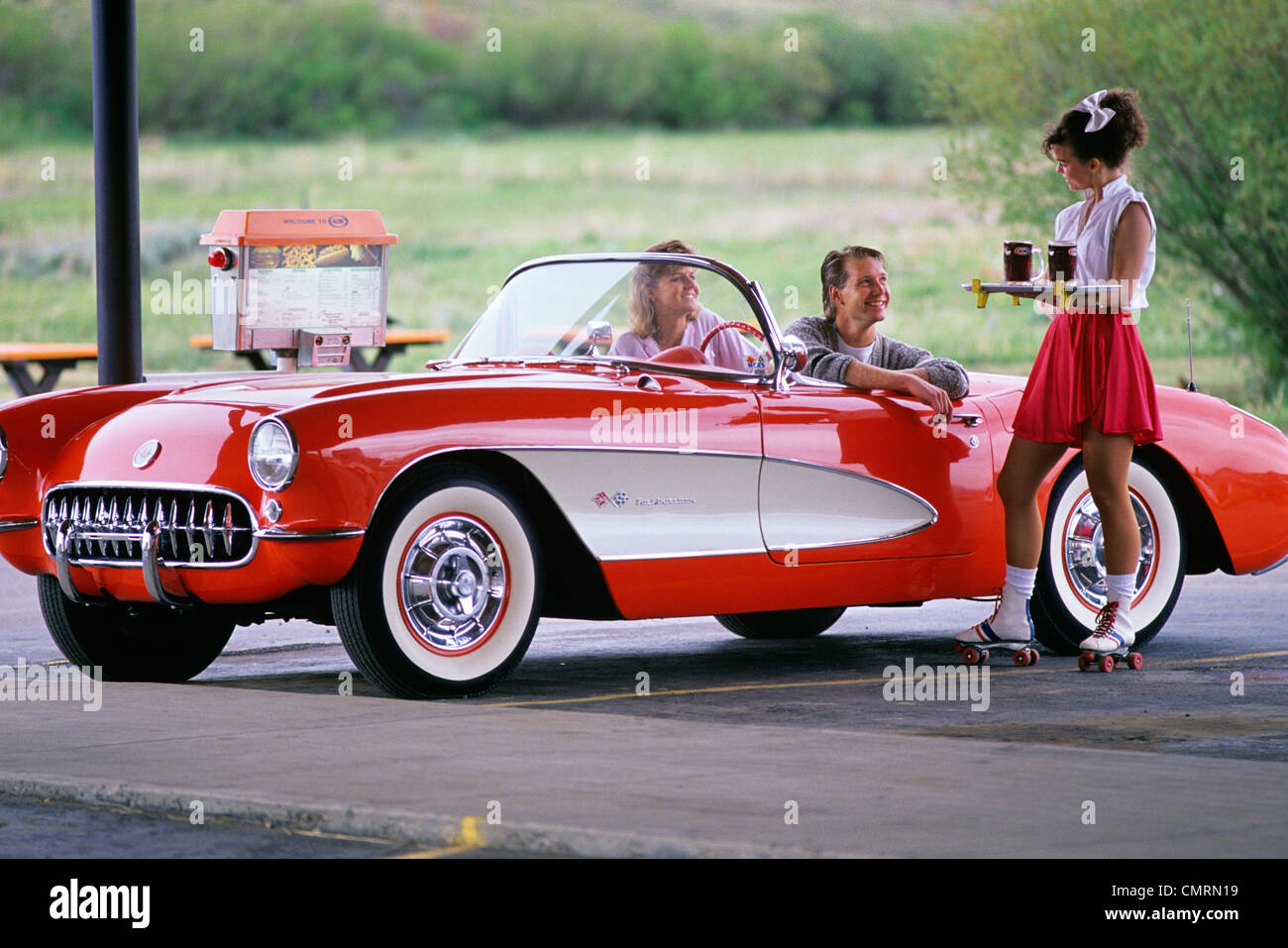 1960 1960s 1980 1980s RETRO COUPLE DRIVE IN WAITRESS ROLLER SKATES SERVER GRANBY COLORADO Stock Photo
