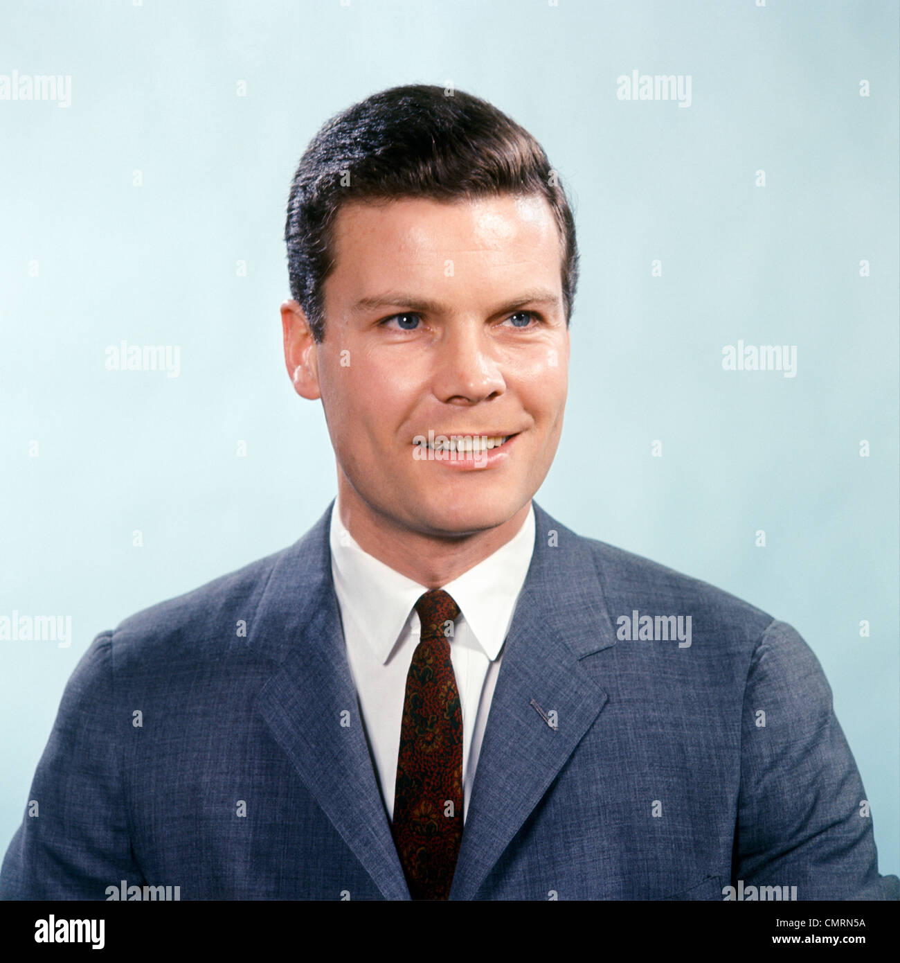 1960 1960s RETRO PORTRAIT SMILING MAN WEARING BLUE GREY SUIT AND TIE Stock Photo