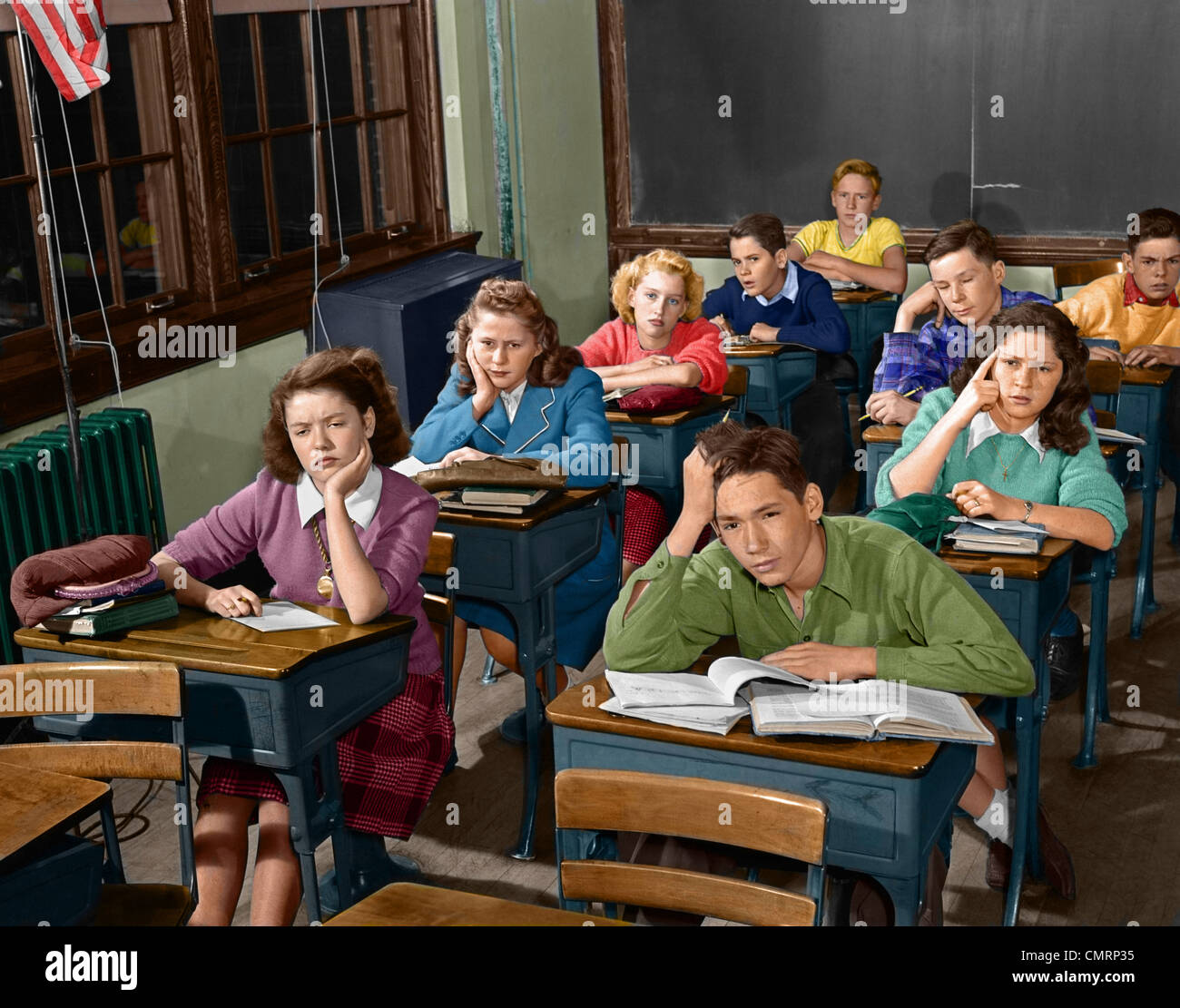 1950s HIGH SCHOOL CLASSROOM OF BORED SLEEPY STUDENTS SITTING AT DESKS Stock Photo