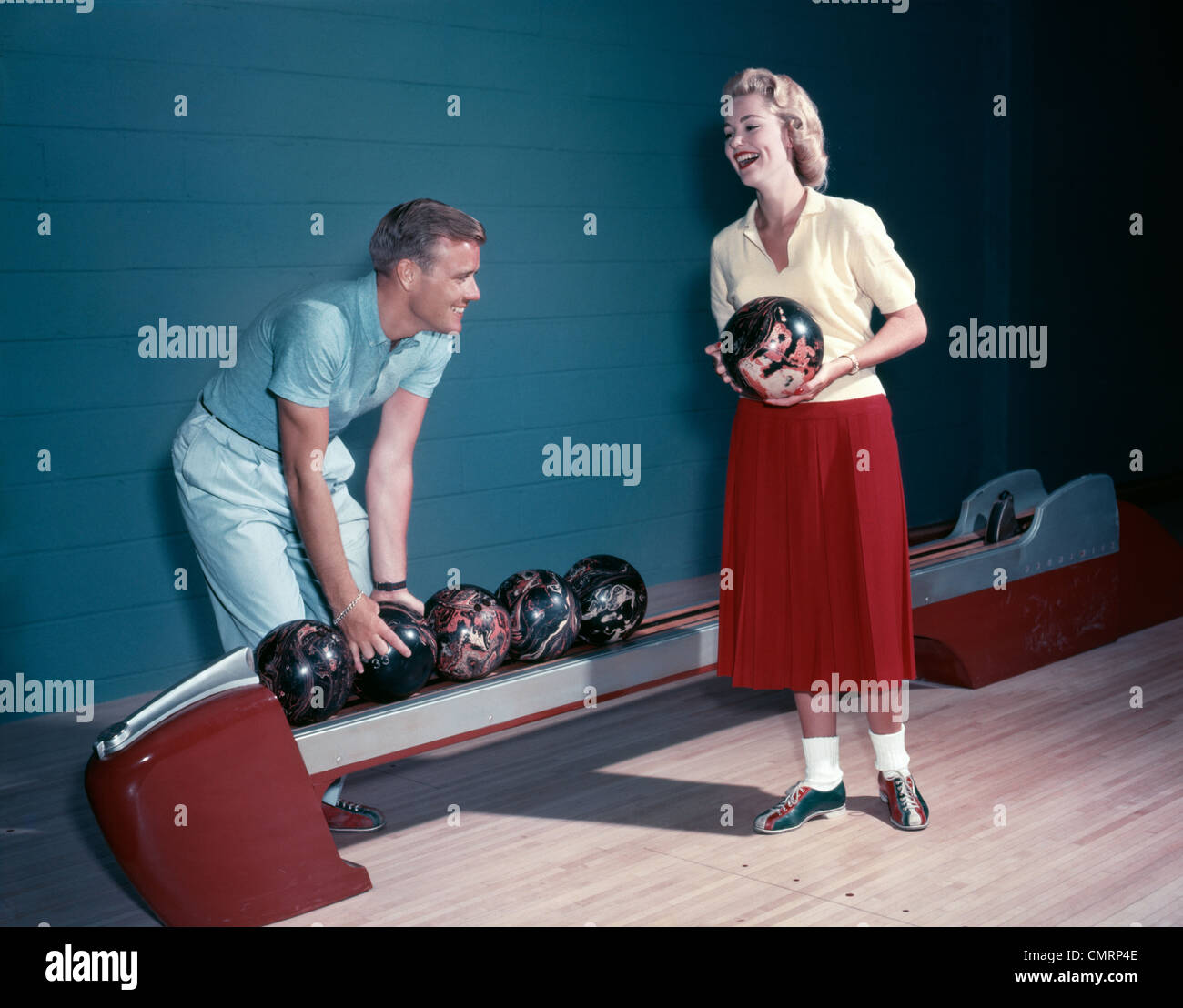 SMILING COUPLE HUSBAND WIFE BOWLING INDOOR 1950s Stock Photo