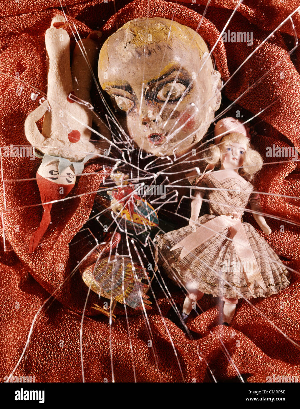 1960 1960s 1970 1970s RETRO STILL LIFE CRACKED BROKEN GLASS TOYS DOLL HEAD ELF GNOME DOLL GIRL DOLL BIZZARE ODD UNUSUAL Stock Photo