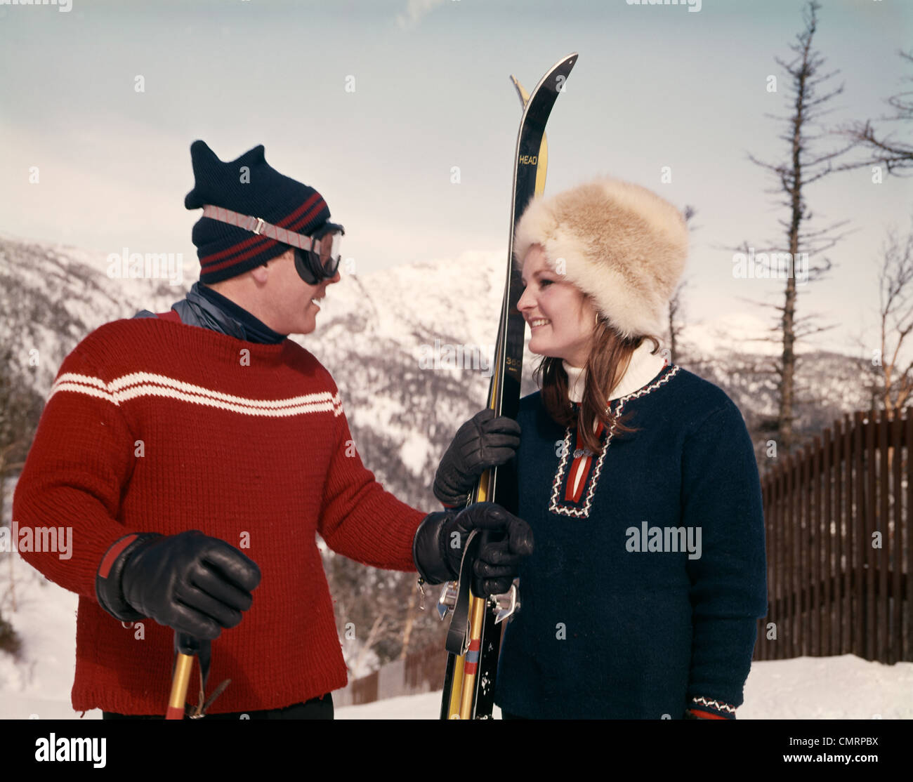 YOUNG COUPLE HUSBAND AND WIFE IN SNOW PREPARING FOR SKIING WINTER OUTDOOR Stock Photo