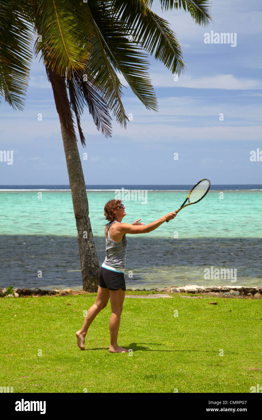 Woman playing tennis, palm tree and coral reef, Crusoe's Retreat, Coral Coast, Viti Levu, Fiji, South Pacific Stock Photo