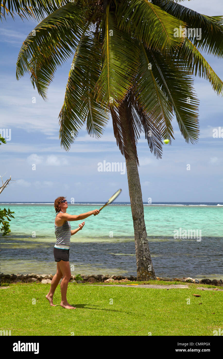 Woman playing tennis, palm tree and coral reef, Crusoe's Retreat, Coral Coast, Viti Levu, Fiji, South Pacific Stock Photo