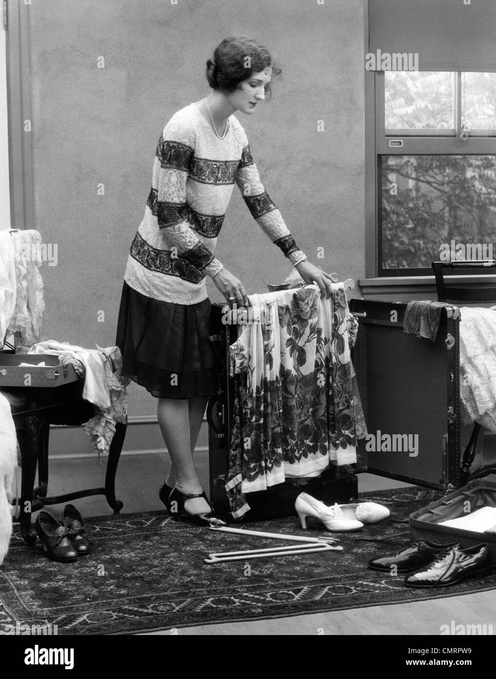 1920s WOMAN PACKING CLOTHES FOR TRAVEL Stock Photo