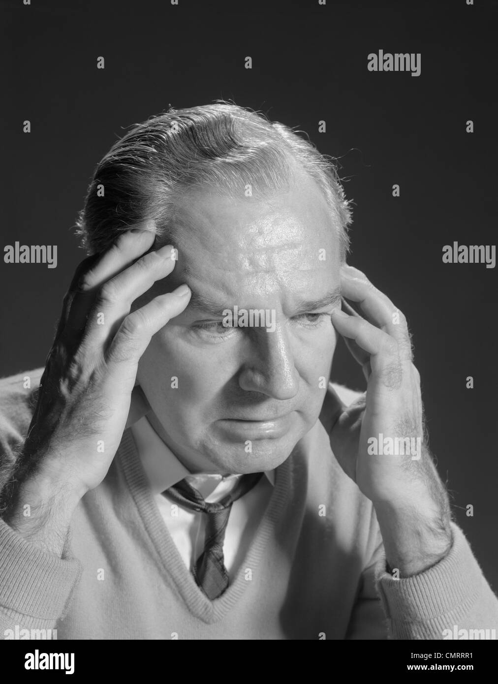 1960s OLDER MAN WITH HANDS HOLDING HEAD TEMPLES Stock Photo