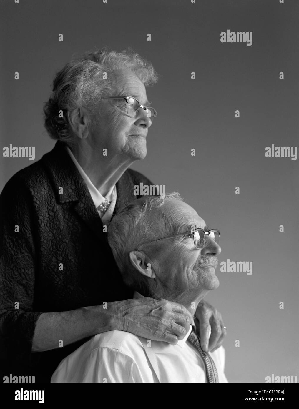 1960s PORTRAIT OF ELDERLY COUPLE IN THEIR 80s TIME WORN HANDS TOUCHING STUDIO Stock Photo
