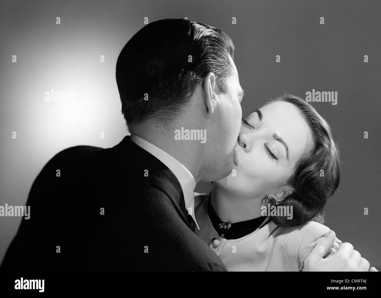 1950s CLOSE-UP OF MAN AND WOMAN KISSING Stock Photo