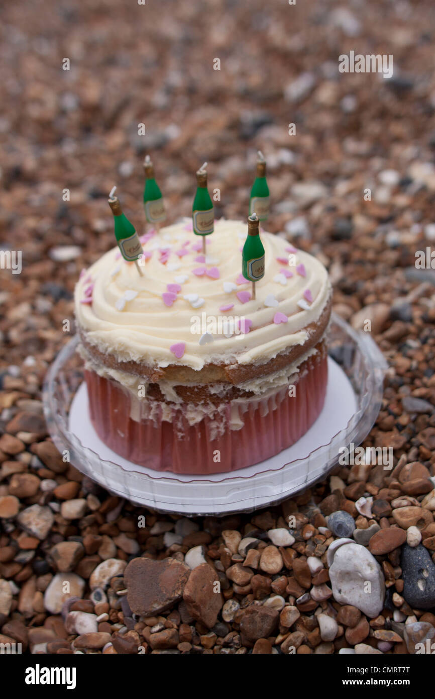 A birthday cake with champagne candles on a pebbled beach Stock Photo -  Alamy, image size:866x1390
