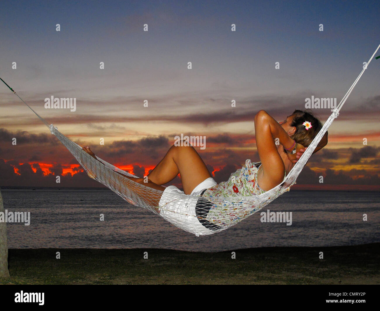 Woman in hammock at sunset, Coral Coast, Viti Levu, Fiji, South Pacific Stock Photo