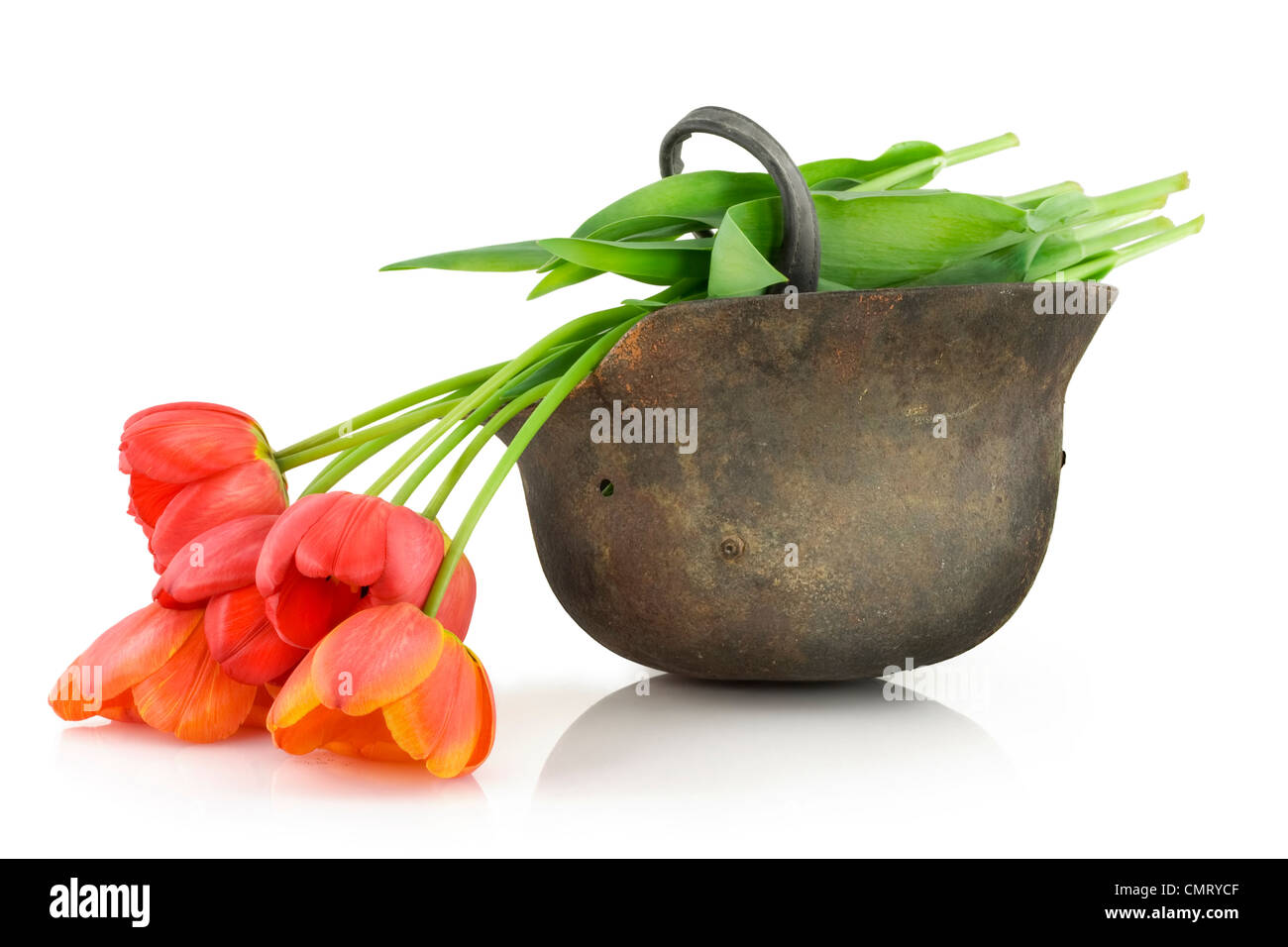 Old rusty a protective helmet of the unknown soldier of the Second World War and tulips. Memories concept Stock Photo