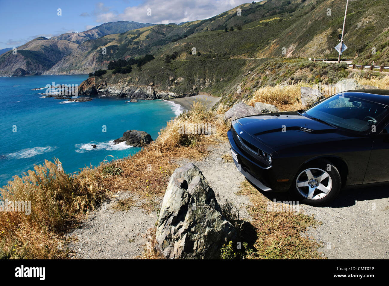 car parked near cliff edge in usa california with blue sky and sea ocean and scenic picturesque mountains Stock Photo