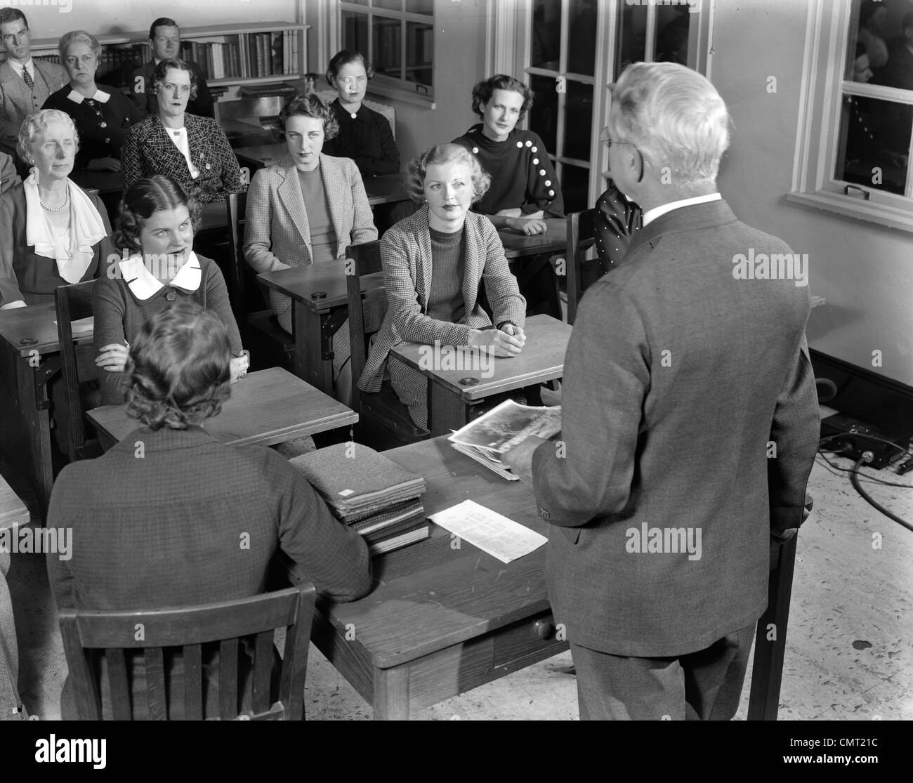 1930s 1940s GROUP MEN AND WOMEN VOCATIONAL TRAINING LECTURE CLASSROOM JOB TRAINING CLASS WITH OLDER TEACHER ADULT EDUCATION Stock Photo