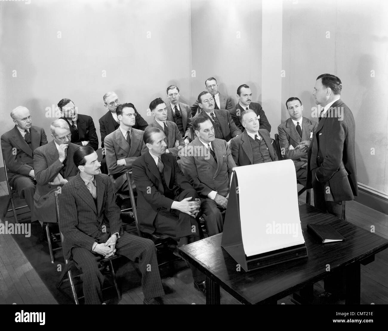 1930s GROUP OF BUSINESSMEN IN TRAINING MEETING LISTENING TO SPEAKER Stock Photo