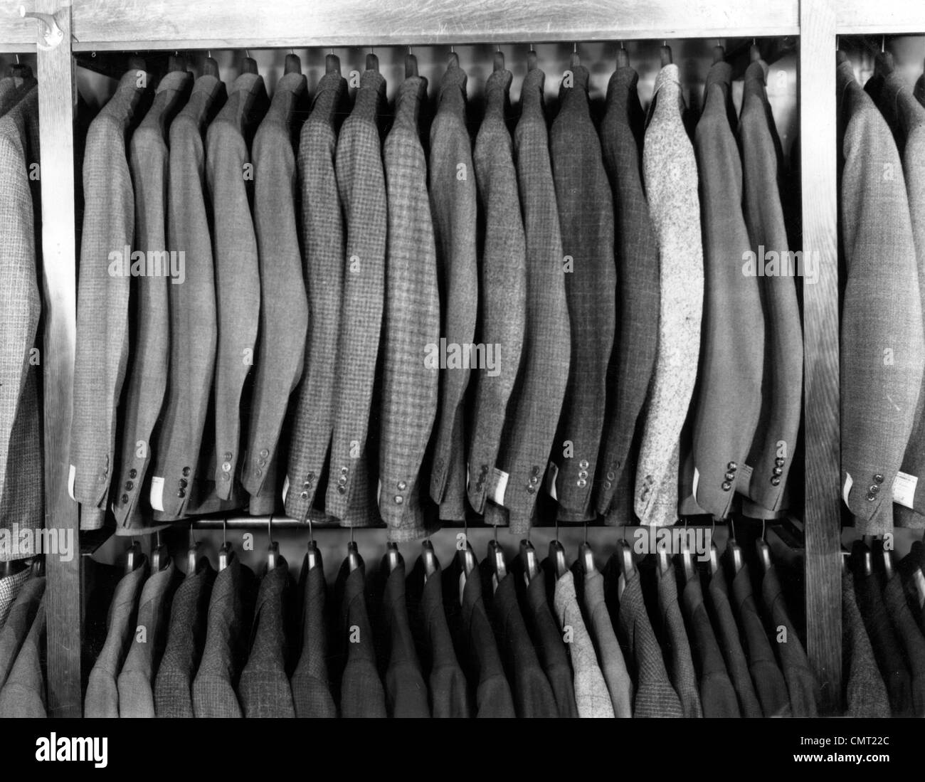1940s RACK OF MEN'S WOOL JACKETS HANGING IN RETAIL STORE MEN'S FASHION CLOTHING SUITS Stock Photo