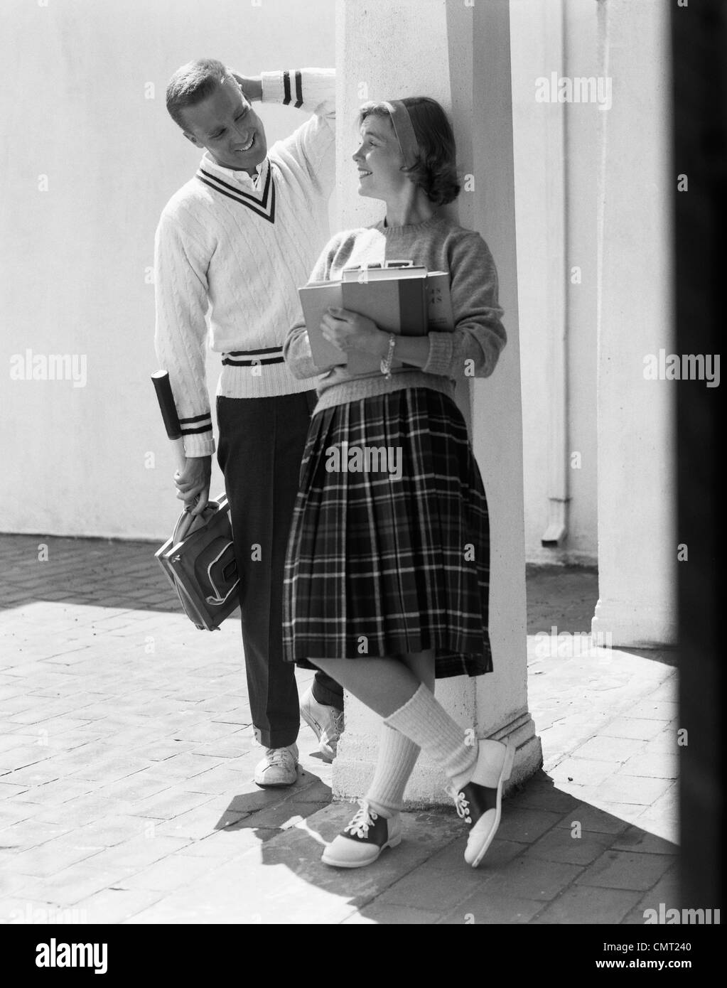1950s 1960s COLLEGE HIGH SCHOOL AGED TEENAGE BOY & GIRL SMILING FLIRTING  WEARING SADDLE SHOES PLAID PLEATED SKIRT TENNIS SWEATER Stock Photo - Alamy