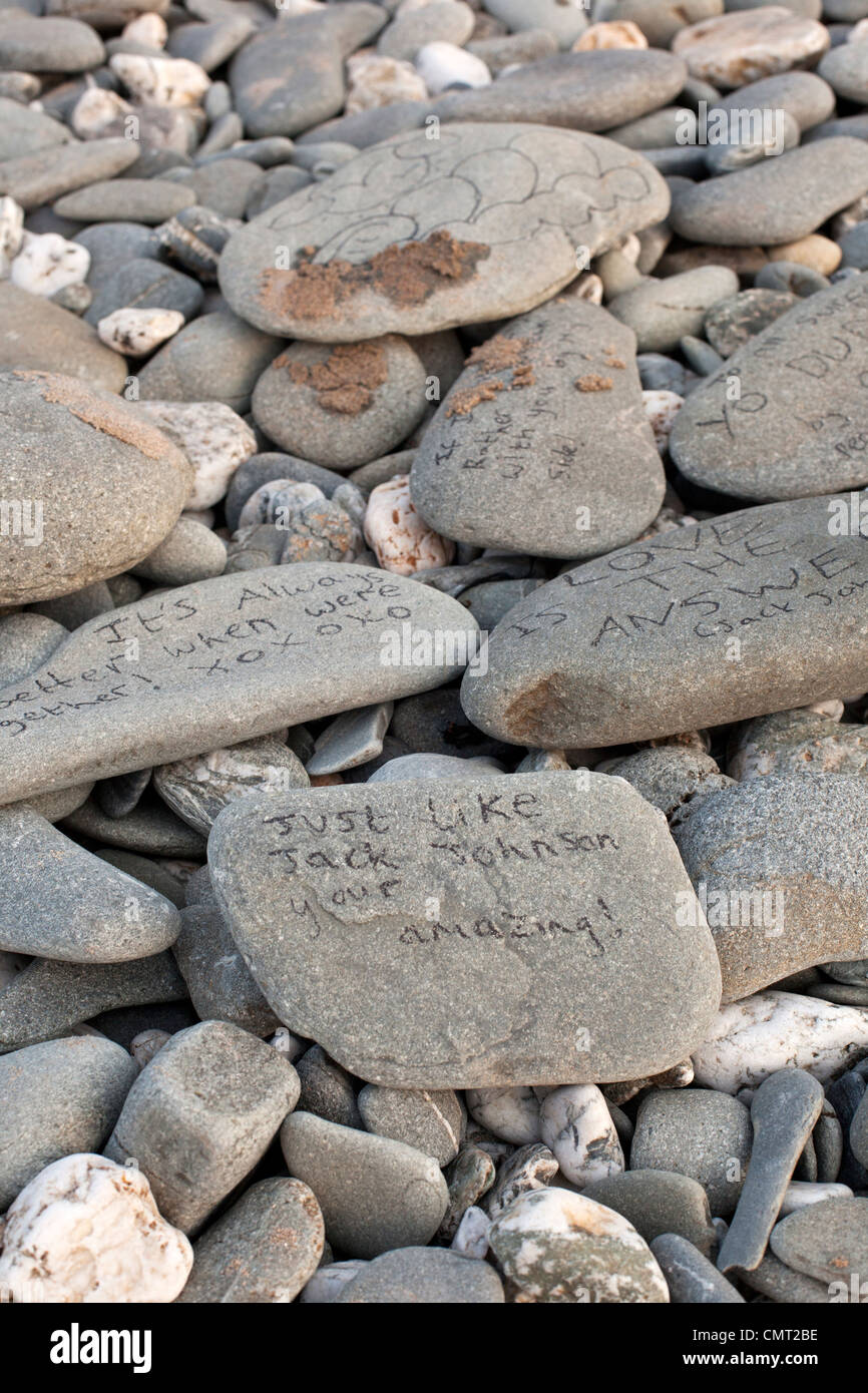 Pebbles on a beach at Gwithian, Cornwall with written messages. Stock Photo