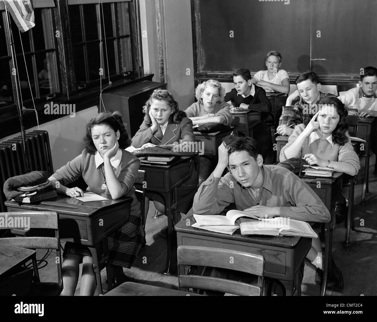 1940s 1950s HIGH SCHOOL CLASSROOM OF BORED STUDENTS SITTING AT DESKS Stock Photo
