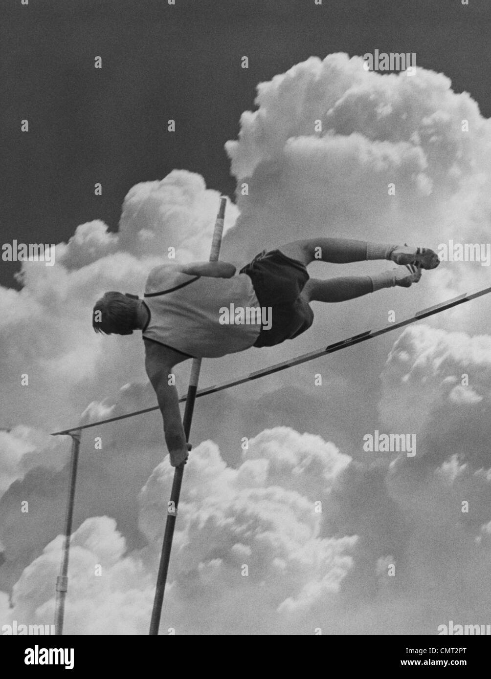 1960s POLE VAULTER MAN AGAINST SKY AND CLOUDS Stock Photo