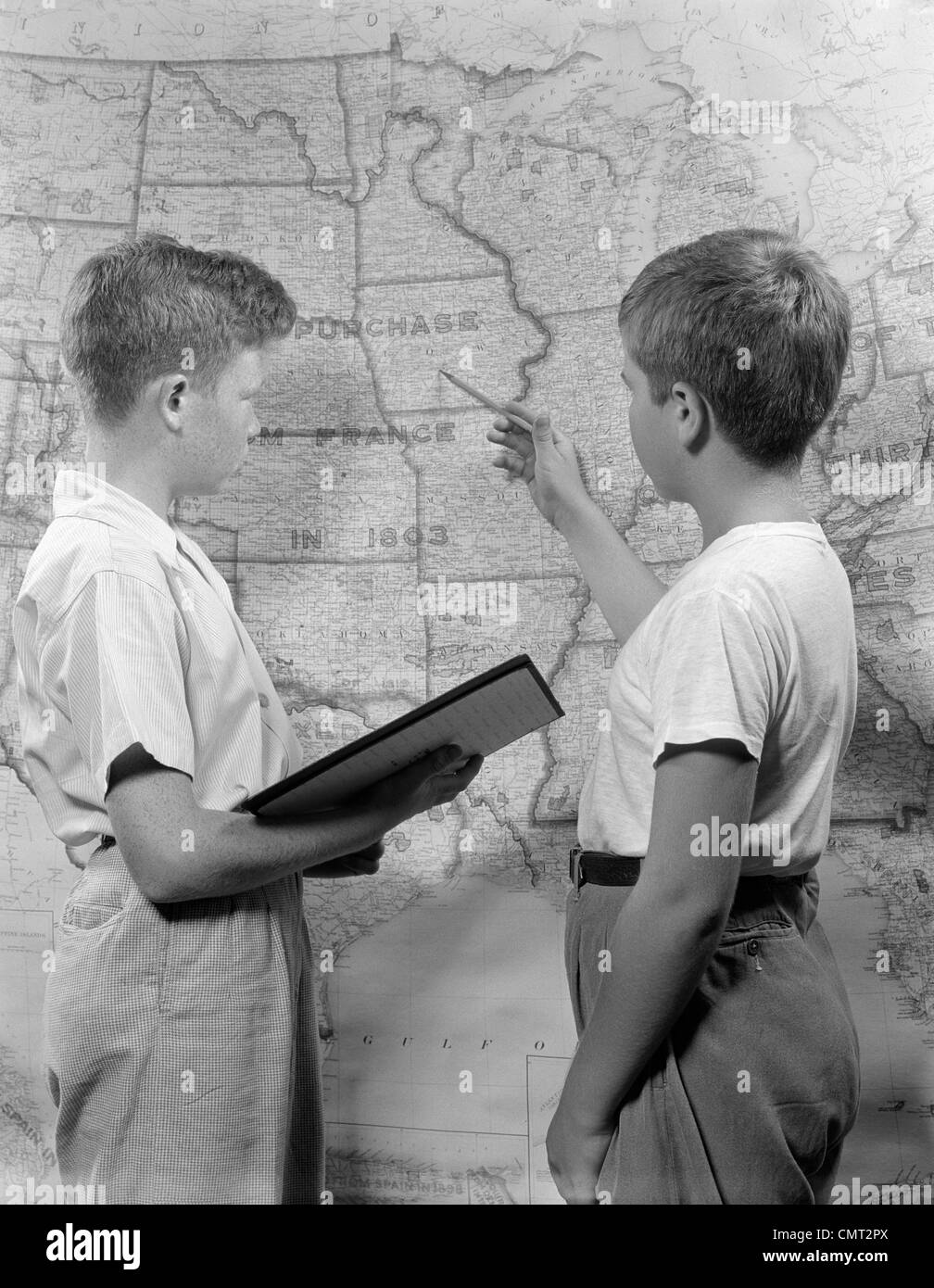 1950s TWO BOYS STUDYING MAP OF LOUISIANA PURCHASE Stock Photo