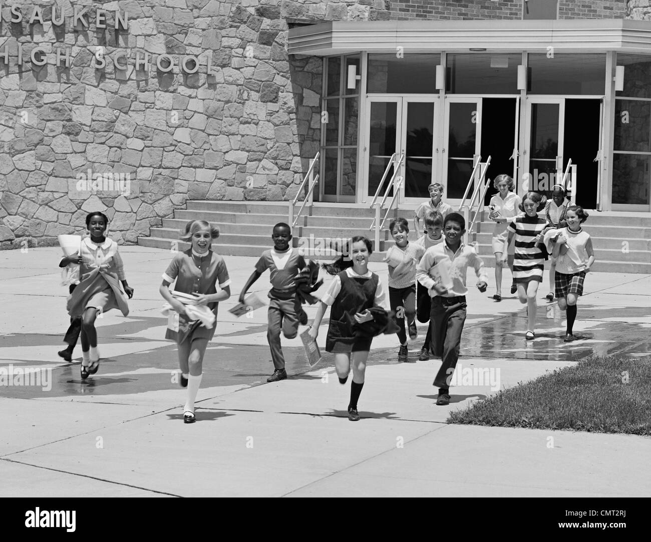 1960s BOYS AND GIRLS STUDENTS RUNNING OUT OF SCHOOL Stock Photo
