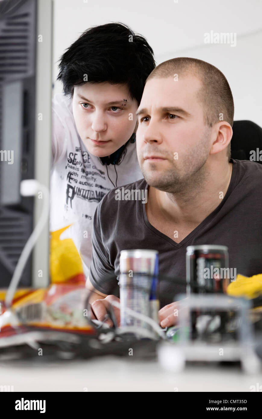 Two people behind computer screen Stock Photo Alamy