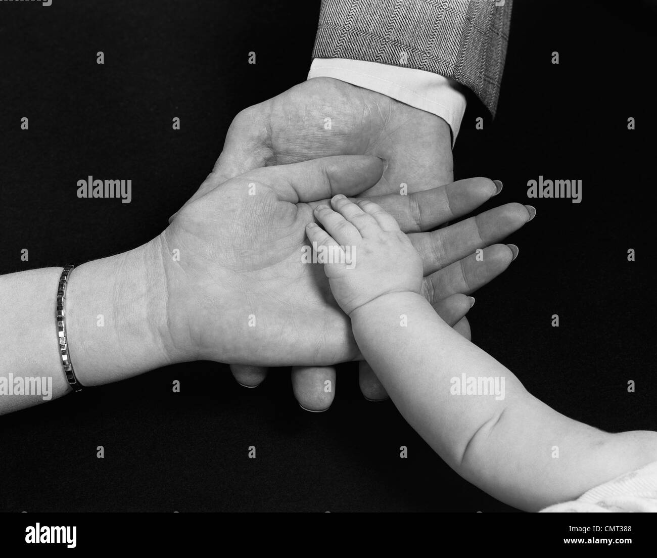 1950s HANDS OF FAMILY MAN WOMAN CHILD MOTHER FATHER BABY Stock Photo