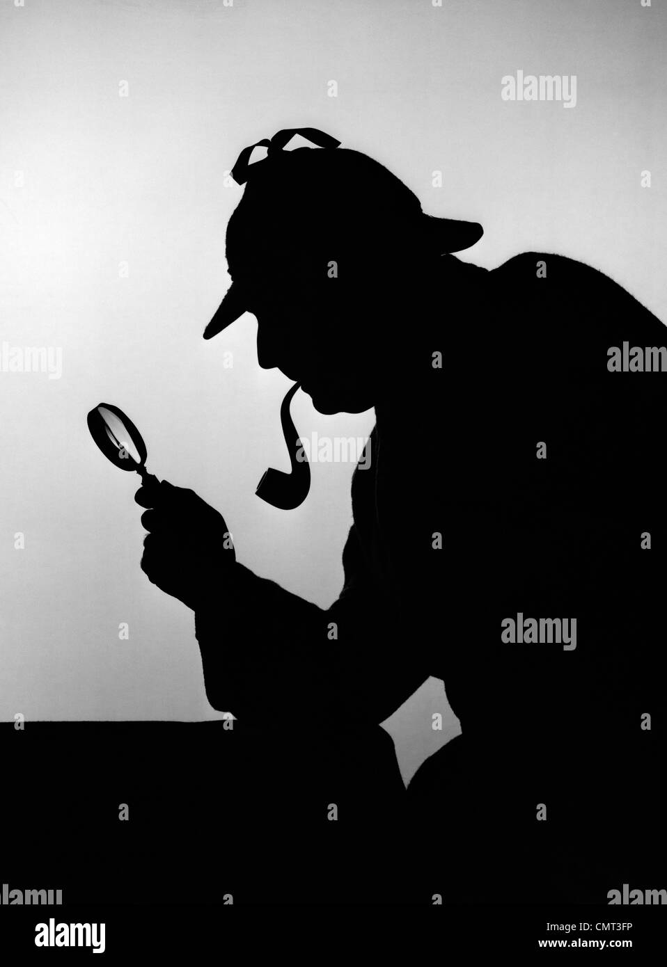 1940s SILHOUETTE OF SHERLOCK HOLMES HOLDING MAGNIFYING GLASS AND SMOKING A PIPE Stock Photo