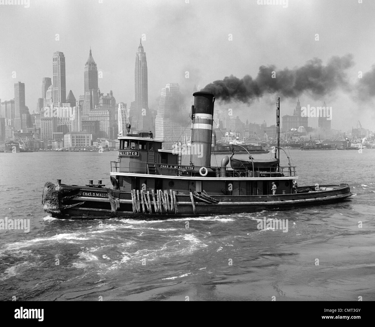 1940s TUGBOAT ON HUDSON RIVER WITH NEW YORK CITY SKYLINE IN SMOKEY