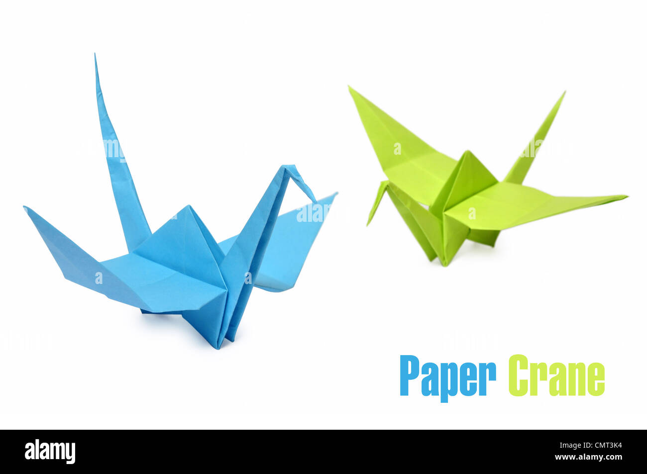 Traditional Japanese origami cranes made from blue and green paper over white background Stock Photo