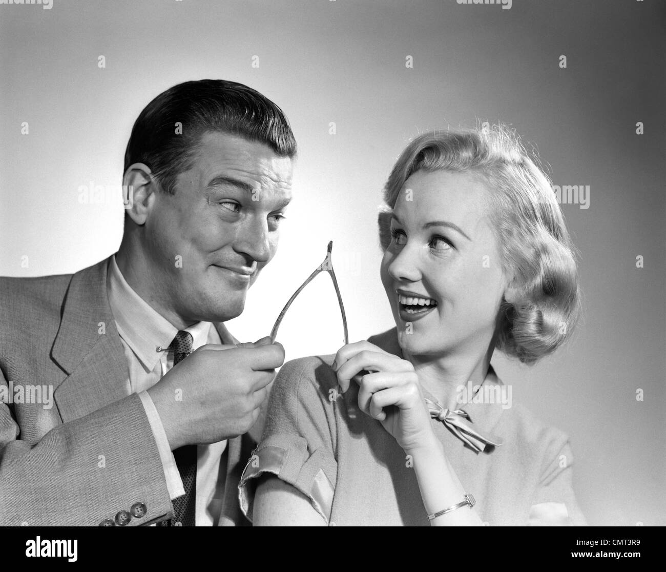 1950s PORTRAIT OF COUPLE HOLDING WISHBONE Stock Photo