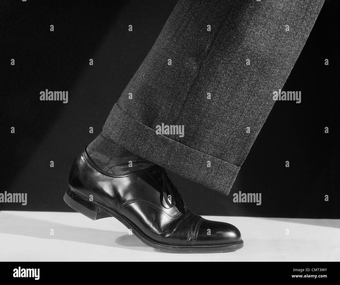 1930s 1940s 1950s WALKING MAN’S SINGLE LEG LEATHER SHOE AND PANT CUFF Stock Photo