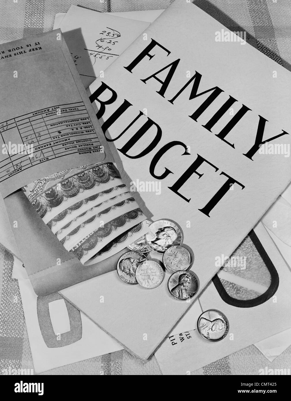 1950s STILL LIFE FAMILY BUDGET MONEY CURRENCY CASH COINS BILLS PAYROLL ENVELOPE Stock Photo