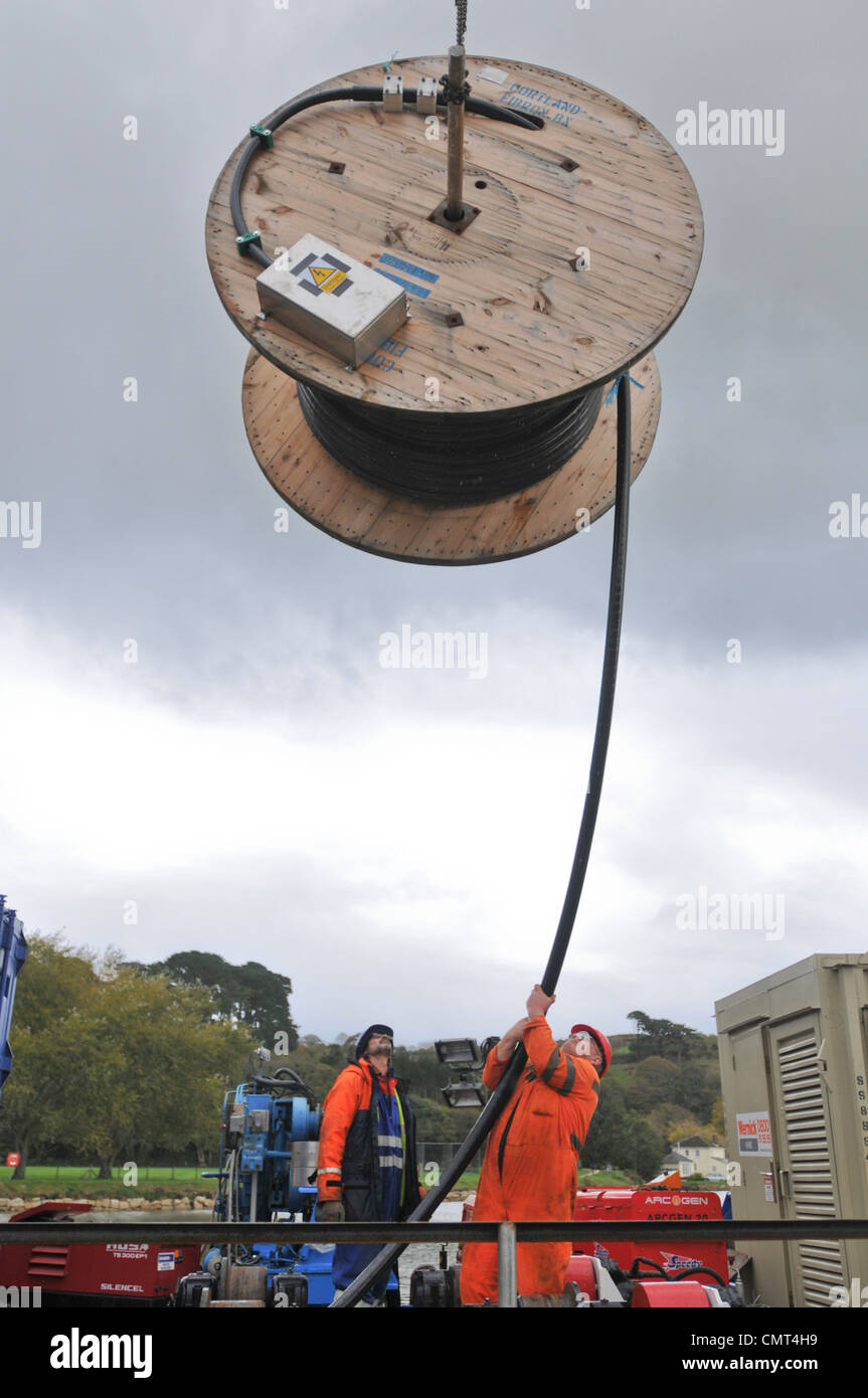 Workers loading cable onto barge, Truro, Cornwall, England, UK Stock Photo