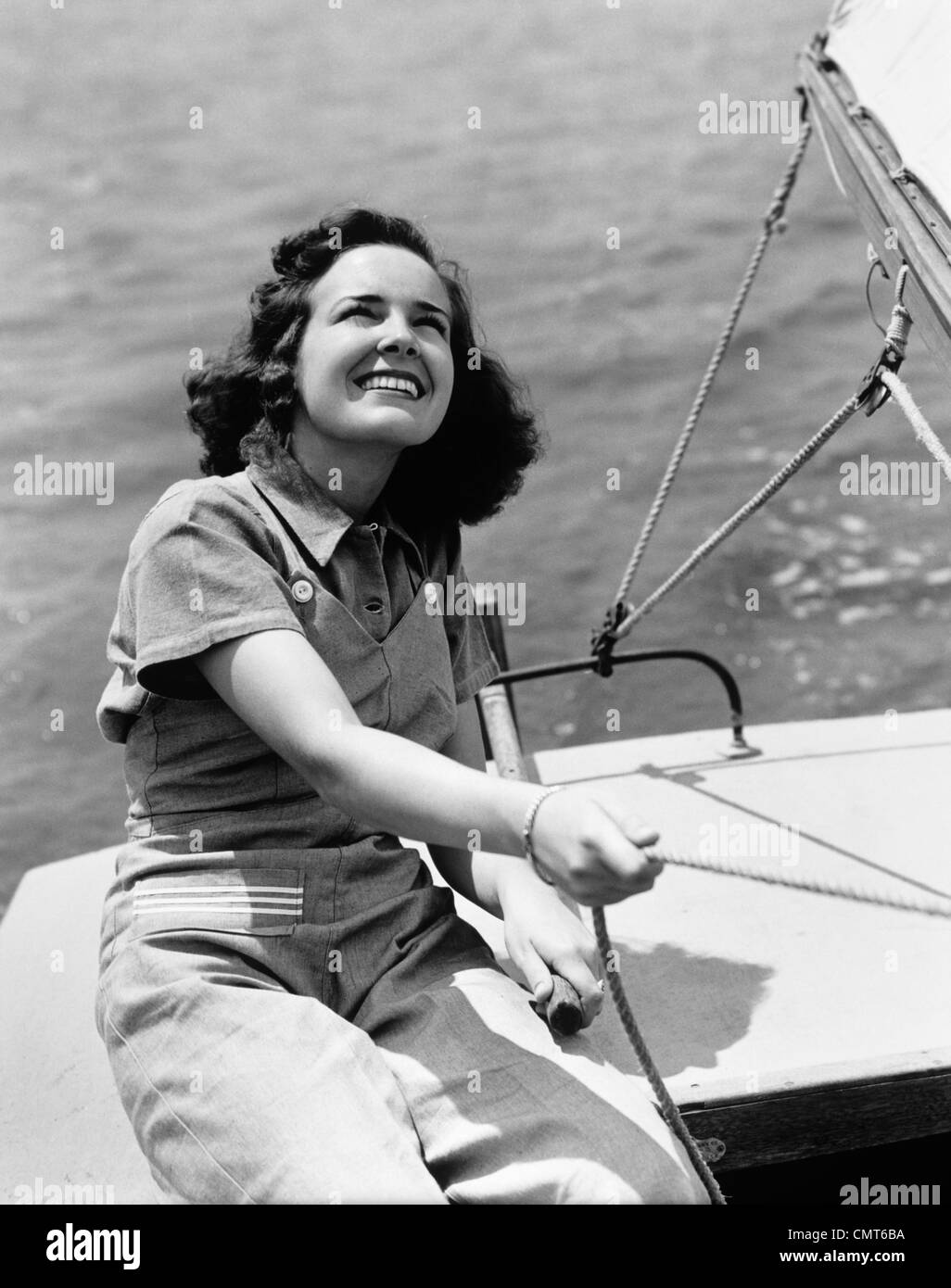 1940s WOMAN SAILOR SMILING SAILING BOAT OUTDOOR Stock Photo