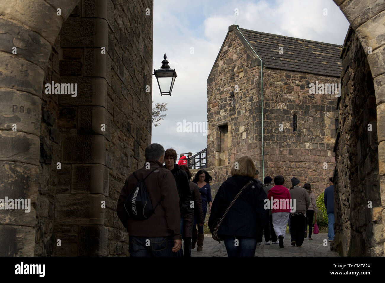 Tourists passing through a narrower passage between a number of old ...