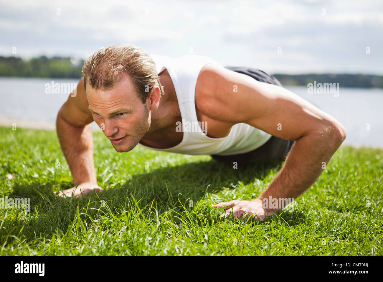 Man doing push-ups on grass Stock Photo - Alamy