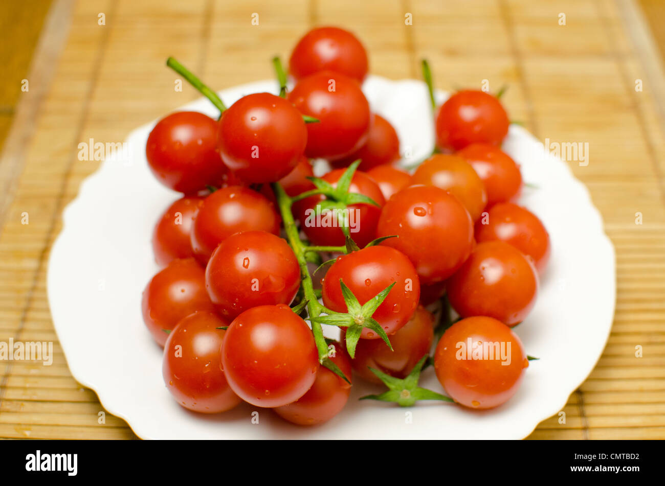 A bunch of tomatoes on a plate, shallow death of the field. Stock Photo
