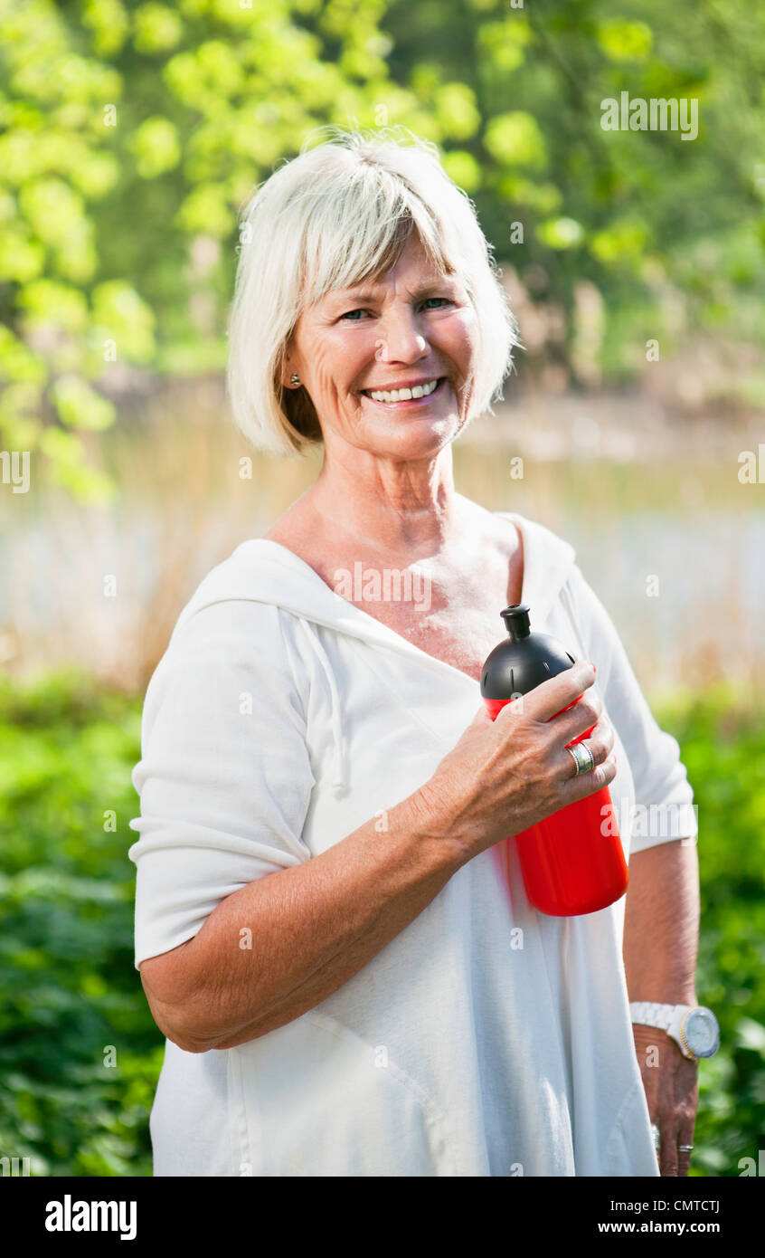 Portrait of woman holding water bottle looking at camera Stock Photo ...