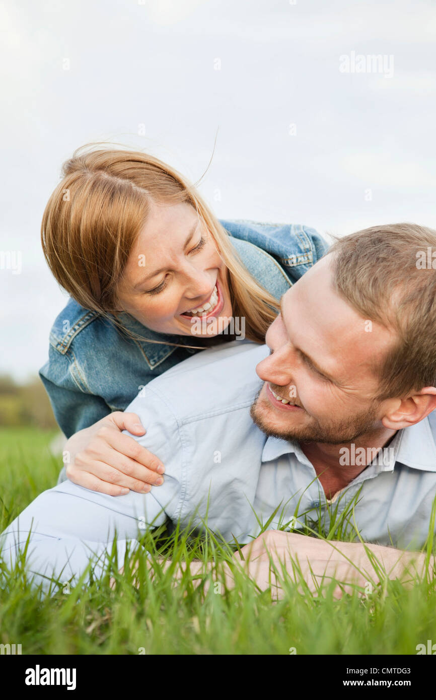 Happy couple lying on grass Stock Photo - Alamy