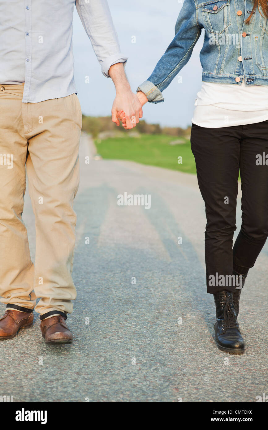 Couple holding hands while walking Stock Photo - Alamy