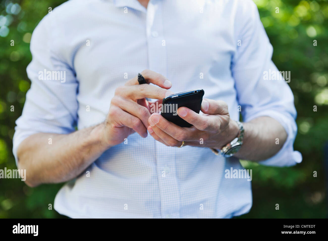 Midsection of man using cell phone Stock Photo