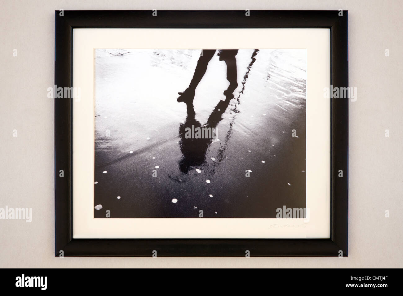 Framed black and white photograph of pedestrian on wet pavement Stock Photo