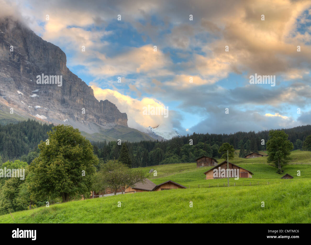 Mountain huts in valley at sunset in front of mountain Eiger north face, Switzerland Stock Photo