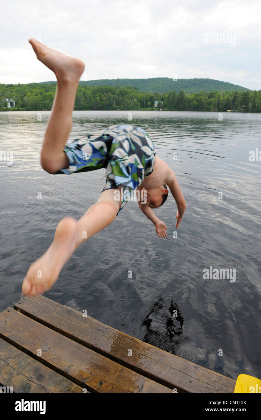 Boy diving off a dock into Lac des Neiges, near Shawinigan, Quebec Stock Photo