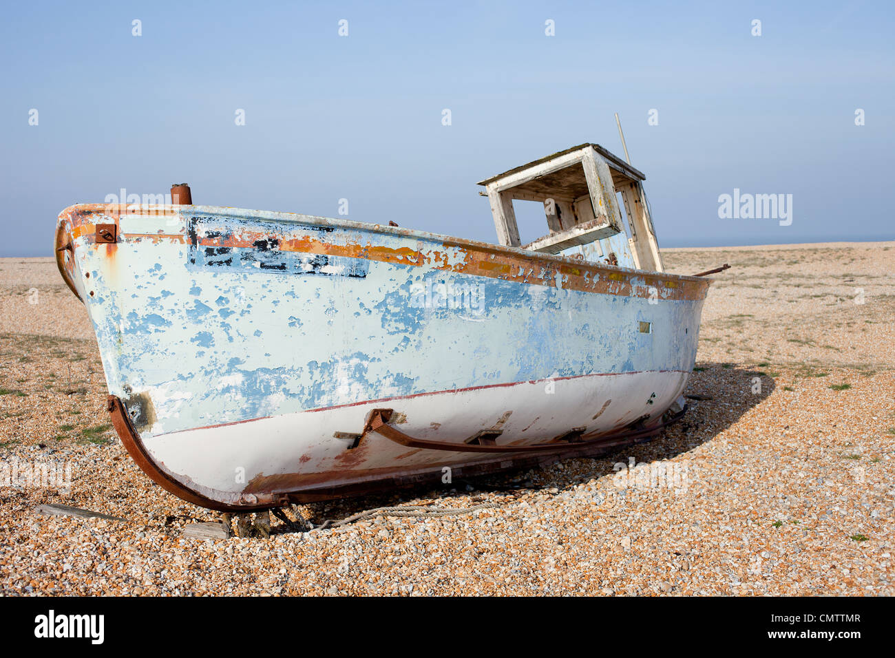 Old fishing boat on the beach against a clear blue sky Stock Photo - Alamy